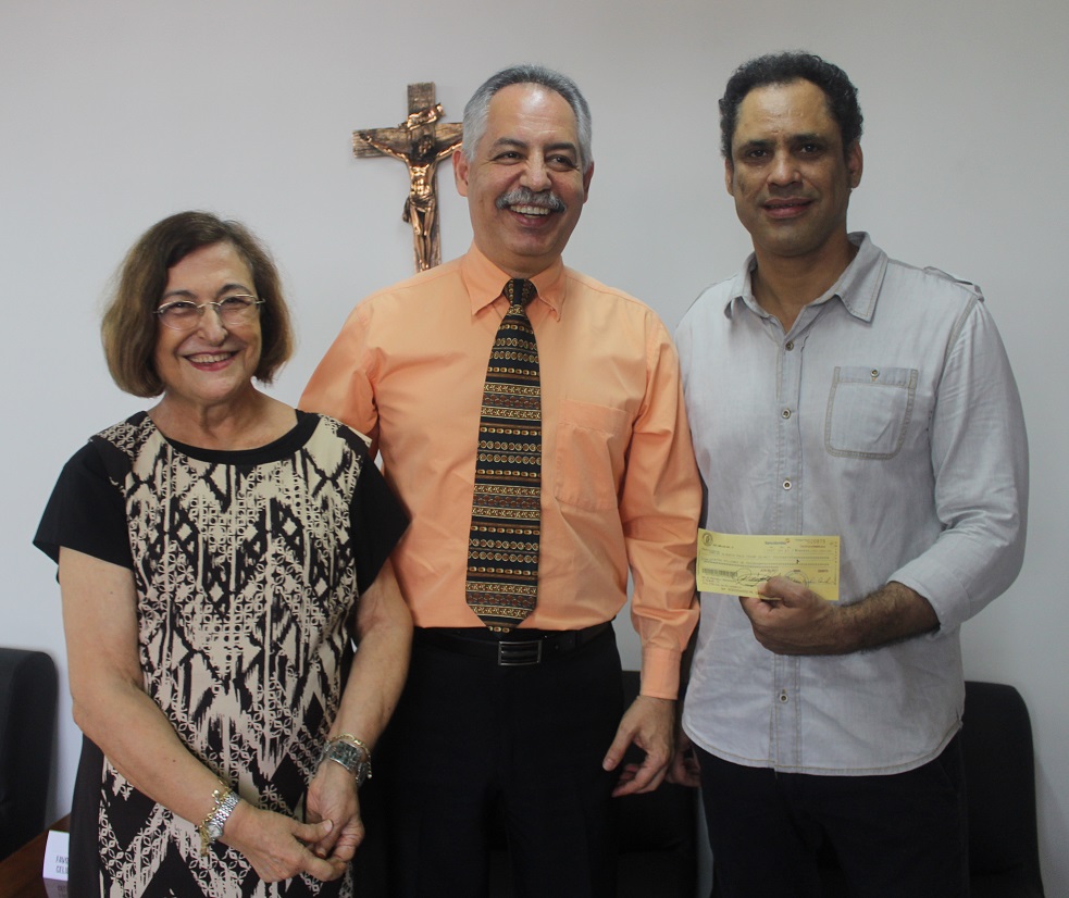 La directora del Área Cultural, Emilia Sáenz de Ibarra y el rector Juan José Acosta Ossio entregan el premio al escritor barranquillero Carlos Polo.