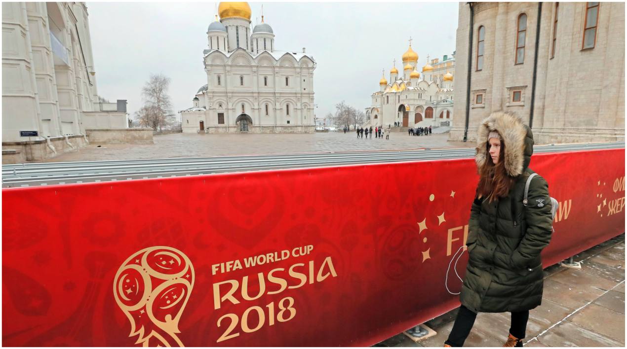 Una mujer pasa junto a un cartel de la Copa del Mundo frente al palacio del Kremlin.