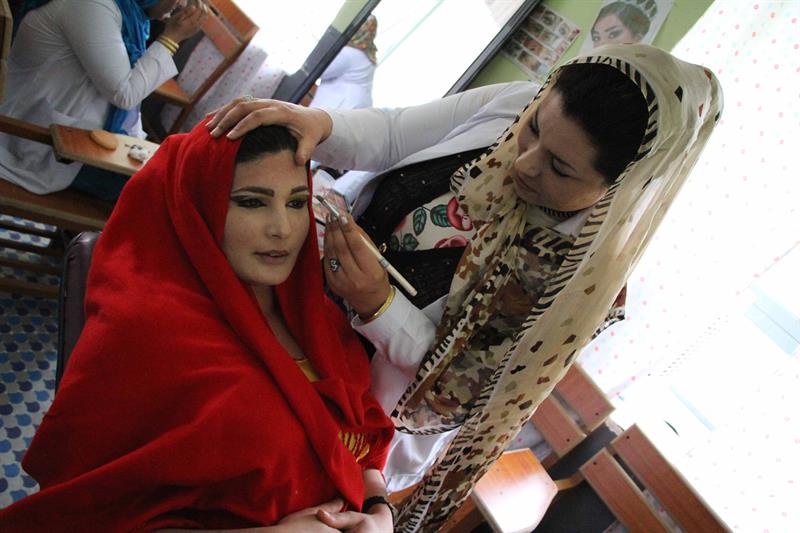 Una mujer víctima de la violencia se maquilla en Afganistán, antes de un evento relacionado con el Día de la Mujer