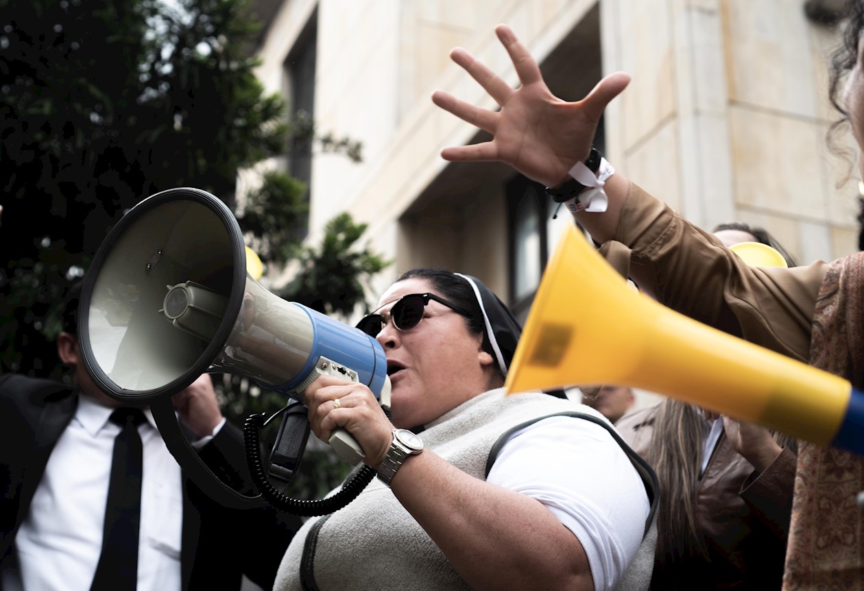 Una religiosa, megáfono en mano, respalda al expresidente Uribe.