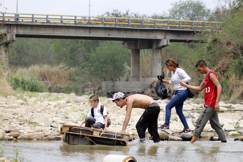 Estudiantes venezolanos cruzan hacia Colombia por el río debido al cierre de los pasos fronterizos hoy.