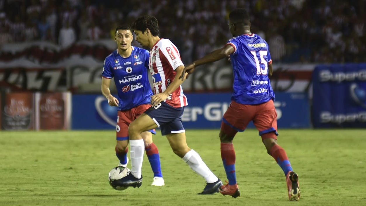 Matías Fernández conduciendo el balón frente a dos adversarios.
