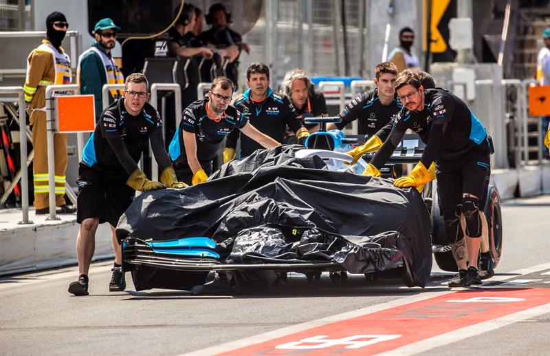  Los mecánicos del piloto británico de la escudería Williams de Fórmula Uno, George Russell, empujen su coche hasta el garaje del equipo tras un accidente durante la primera sesión de entrenamientos libres.