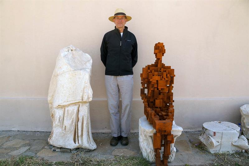 El artista británico Antony Gormley y una de sus esculturas.