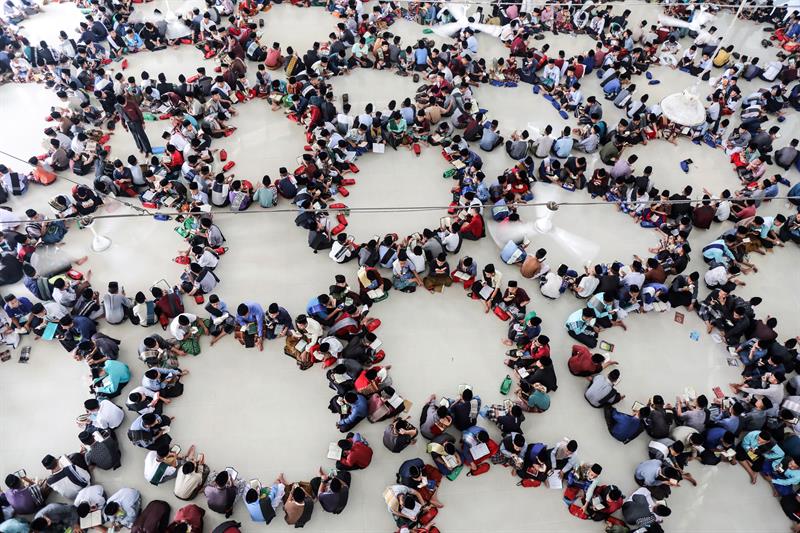  Estudiantes indonesios se sientan en círculos mientras leen el Corán en el primer día de Ramadán, este lunes, en Medan, Indonesia.