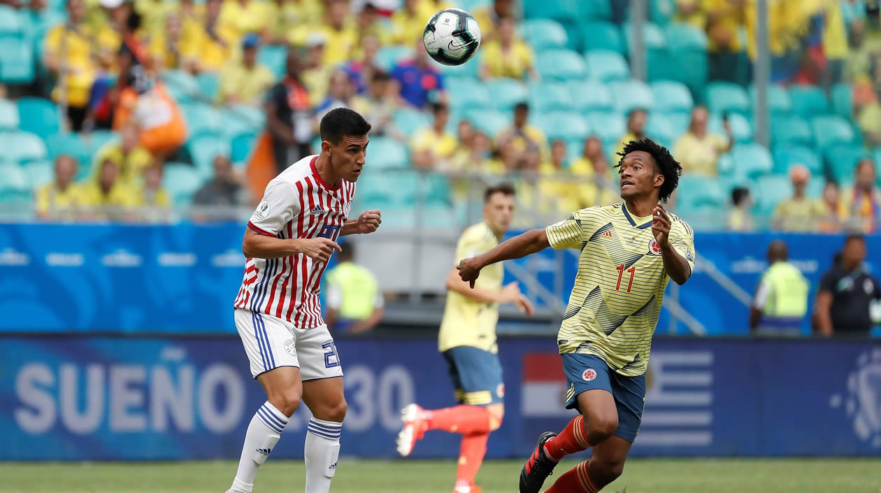 Juan Cuadrado (d) disputa el balón con Óscar Romero de Paraguay, durante el partido Colombia-Paraguay