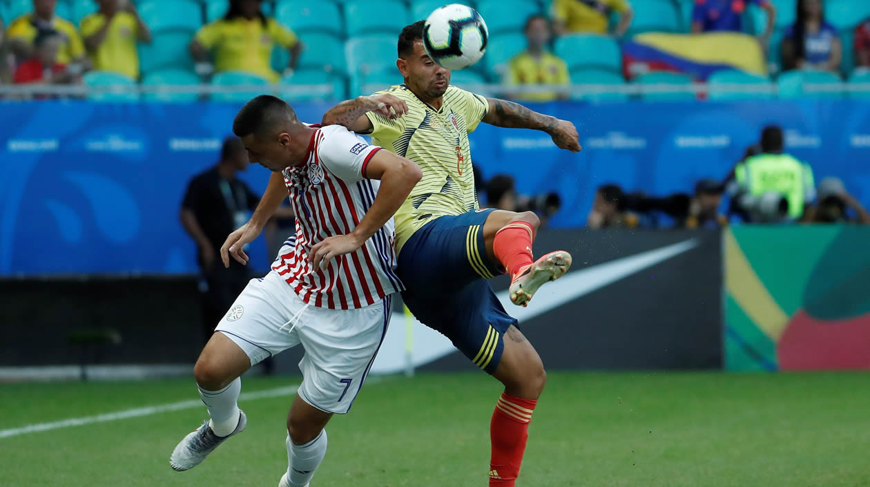 Edwin Cardona (d) disputa el balón con Óscar Cardozo de Paraguay, durante el partido