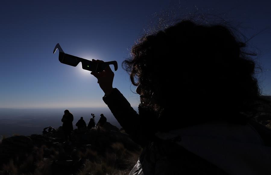 Una persona mira sus anteojos especiales durante el Eclipse solar total, este martes en la ciudad de Merlo, San Luis (Argentina).