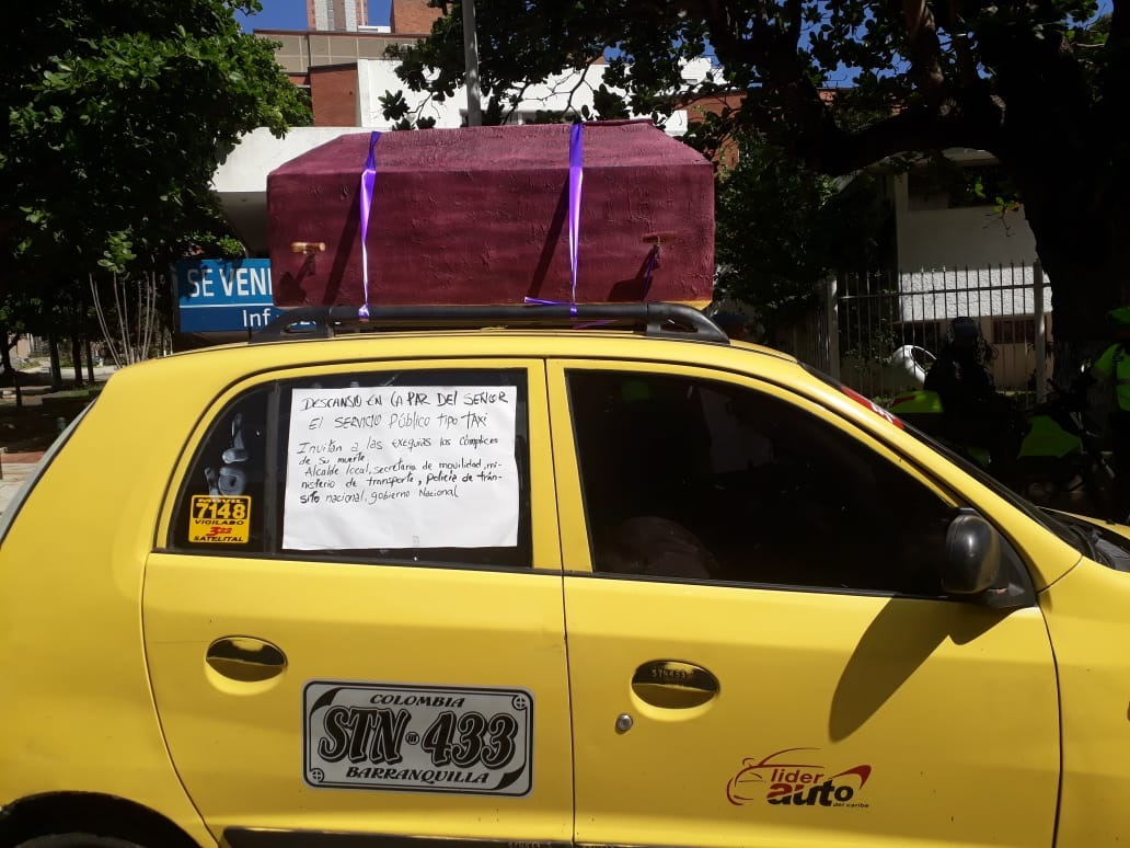 Taxistas en Barranquilla cargan un ataúd en desarrollo de la protesta.