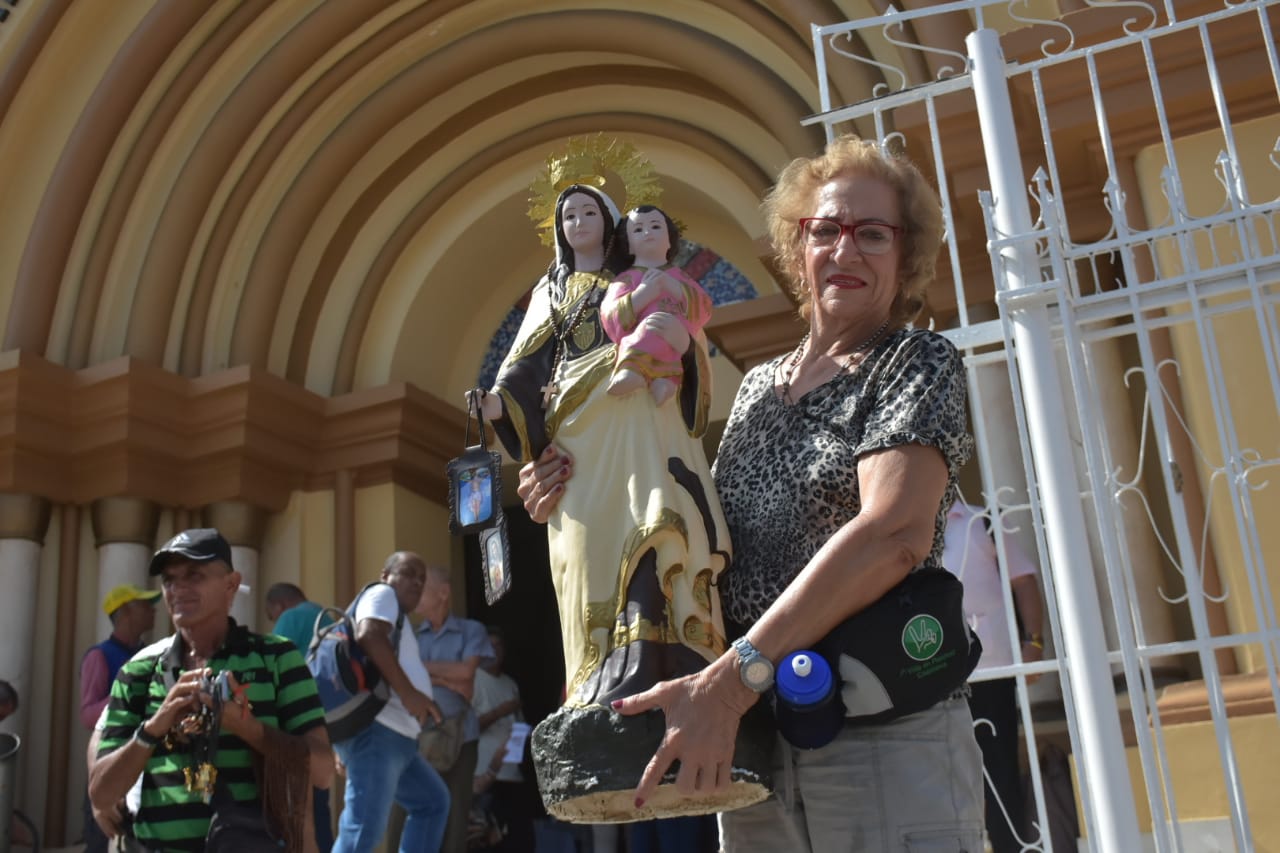 Una devota de la Virgen del Carmen carga una imagen.