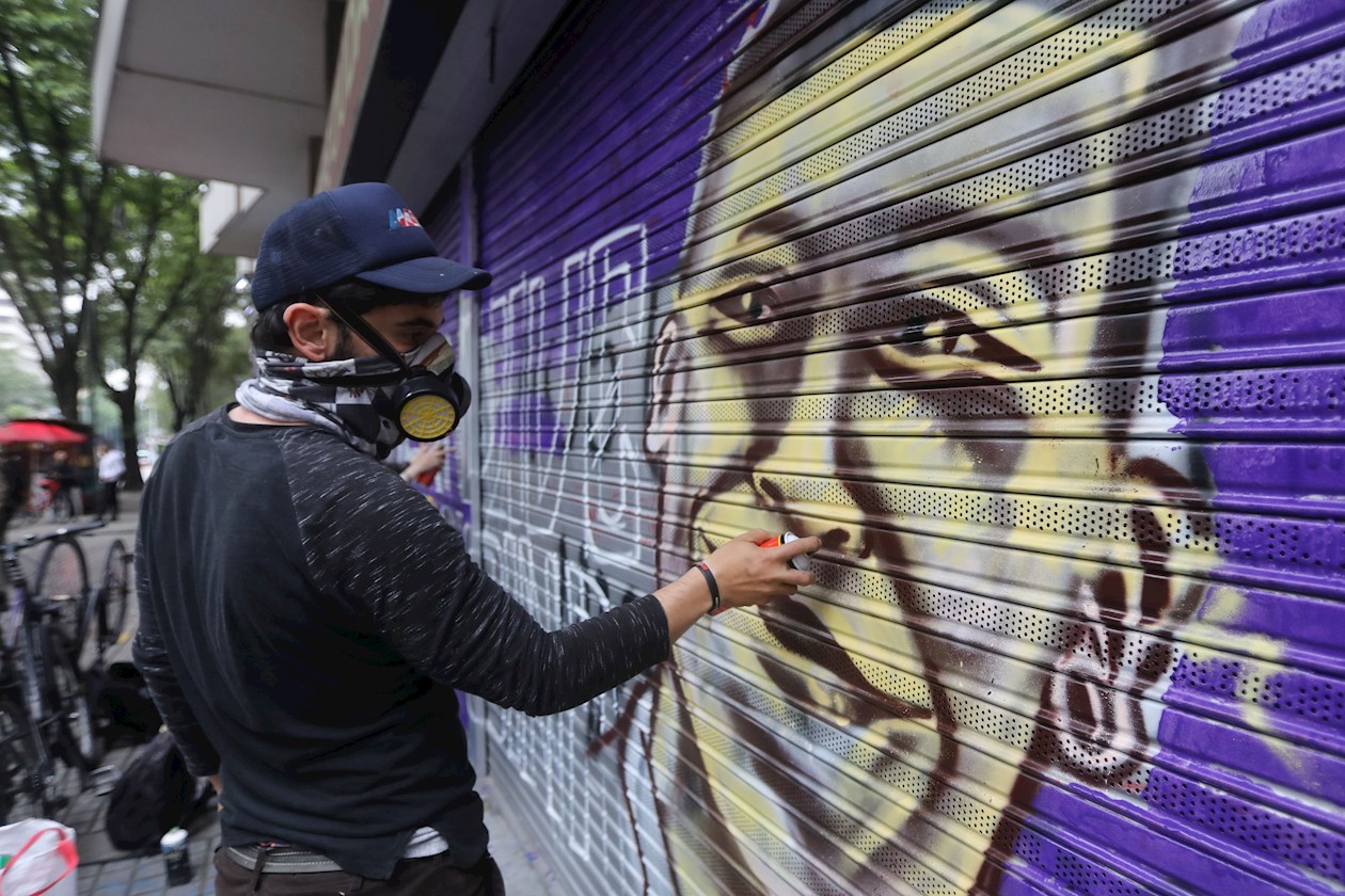 Un artista pinta la cara del fallecido estudiante Dilan Cruz durante la conmemoración del primer año de su muerte hoy, en Bogotá (Colombia).