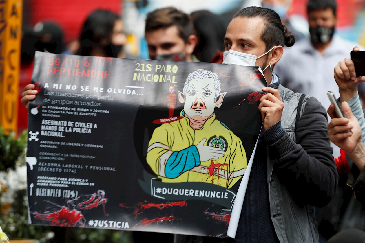 Un hombre sostiene un cartel durante la conmemoración del primer año de la muerte del estudiante Dilan Cruz hoy, en Bogotá (Colombia).