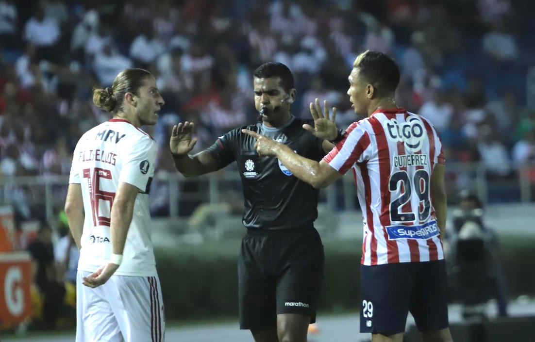 El árbitro Alexis Herrera interviene en una discusión entre Filipe Luis y Teófilo Gutiérrez.