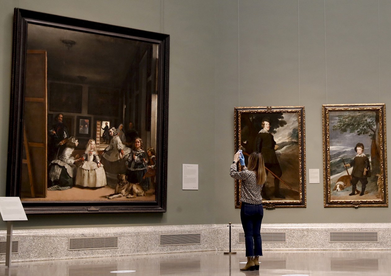 Una periodista fotografía la obra "Las Meninas" de Velázquez a su espalda durante la presentación de "Reencuentro", un espectacular montaje de las obras más emblemáticas de la colección permanente del Museo del Prado que se inaugura el sábado y se extenderá hasta el 13 de septiembre en la Galería Central de la Pinacoteca.