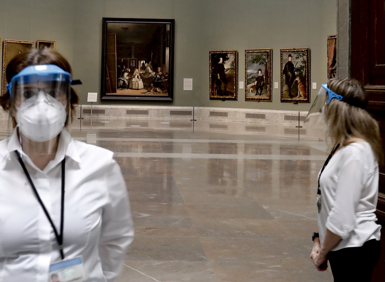 Dos empleadas del Museo del Prado con máscarillas y pantallas protectoras durante la presentación de "Reencuentro".