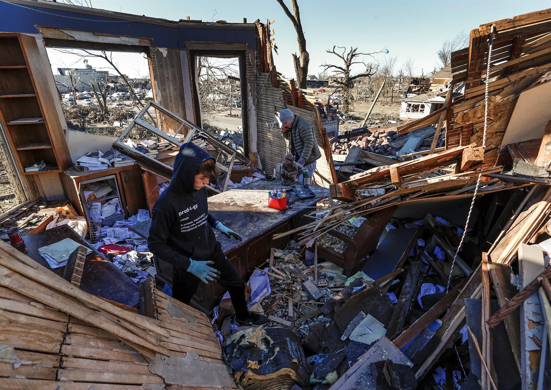 Carson Neeley y su padre, el abogado Bo Neeley (R), remueven los escombros en su oficina tras el tornado en Mayfield, Kentucky, EE. UU.