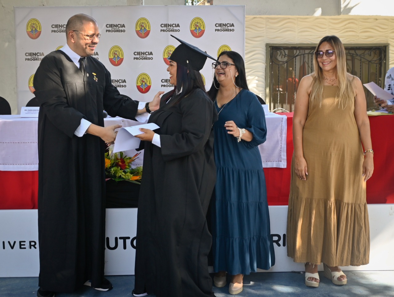 El rector Mauricio Molinares entrega el diploma a una de las graduandas.