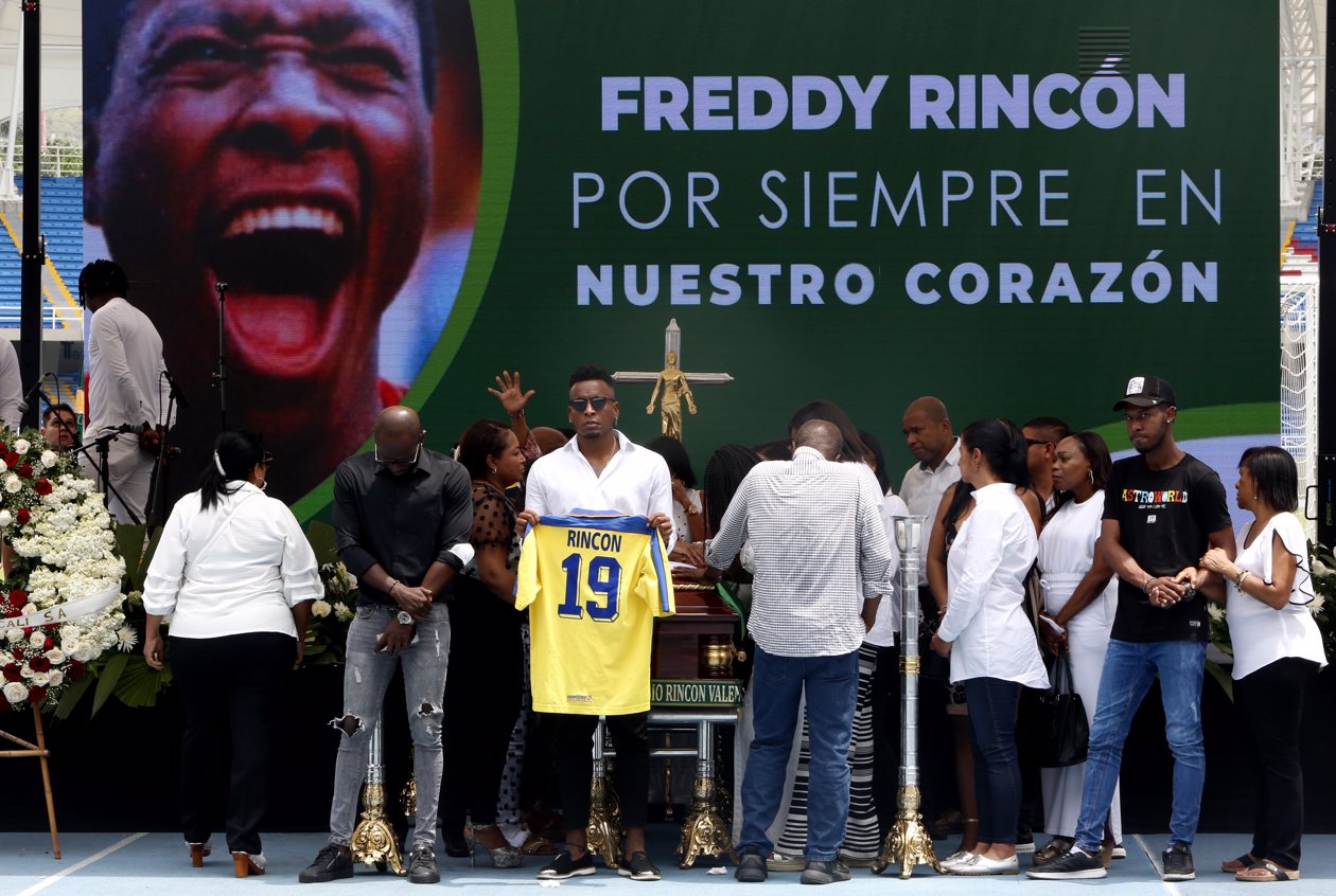Personas e hijos de Freddy Rincón posan junto al féretro del exfutbolista colombiano.