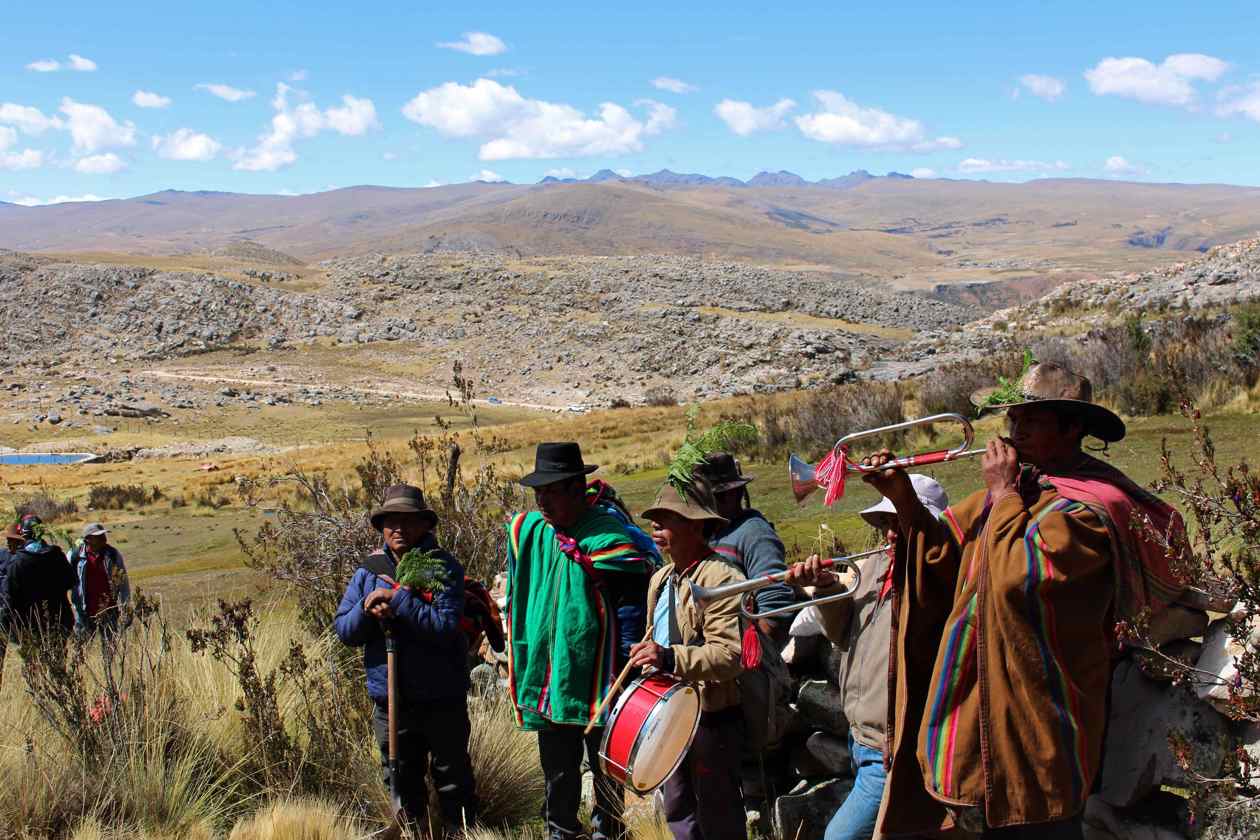 Músicos indígenas y campesinos acompañan un ritual de pago a la tierra durante las labores de "cría de agua"