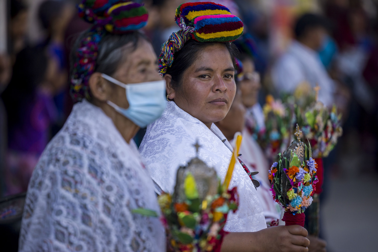  Mujeres sostienen flores durante un evento tradicional, en Rabinal, Guatemala.