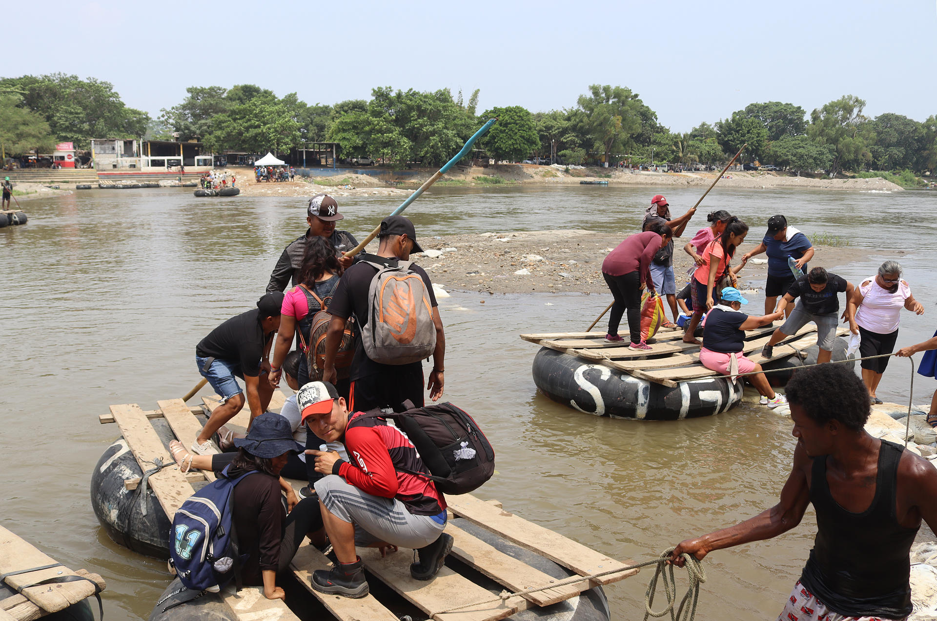 Migrantes cruzan el río Suchiate en balsas hechas con llantas y madera.