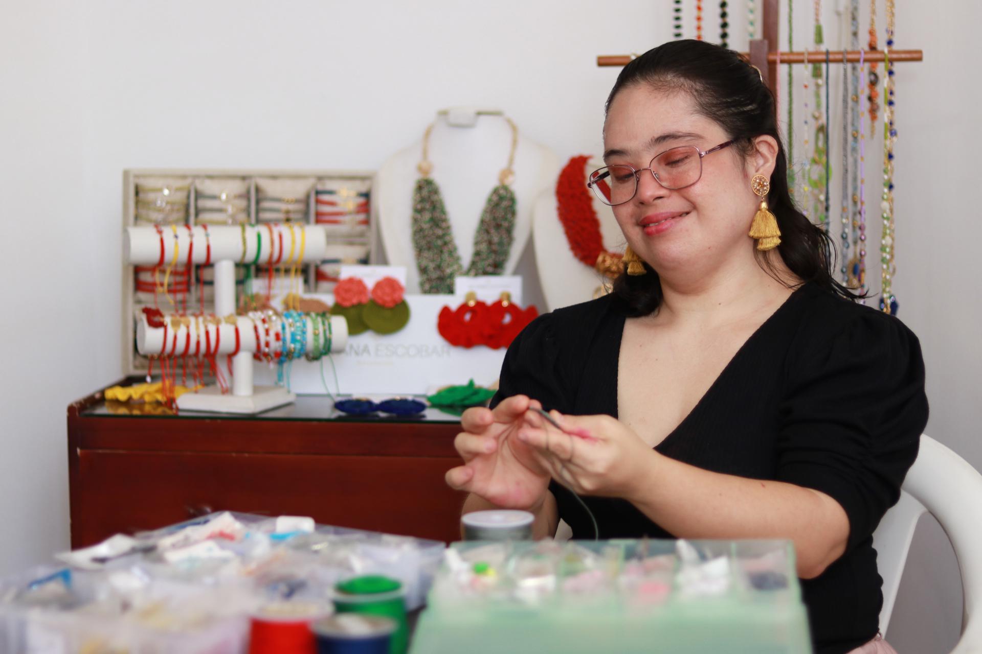 Silvana Escobar, persona con síndrome de Down, trabaja elaborando accesorios en su casa.
