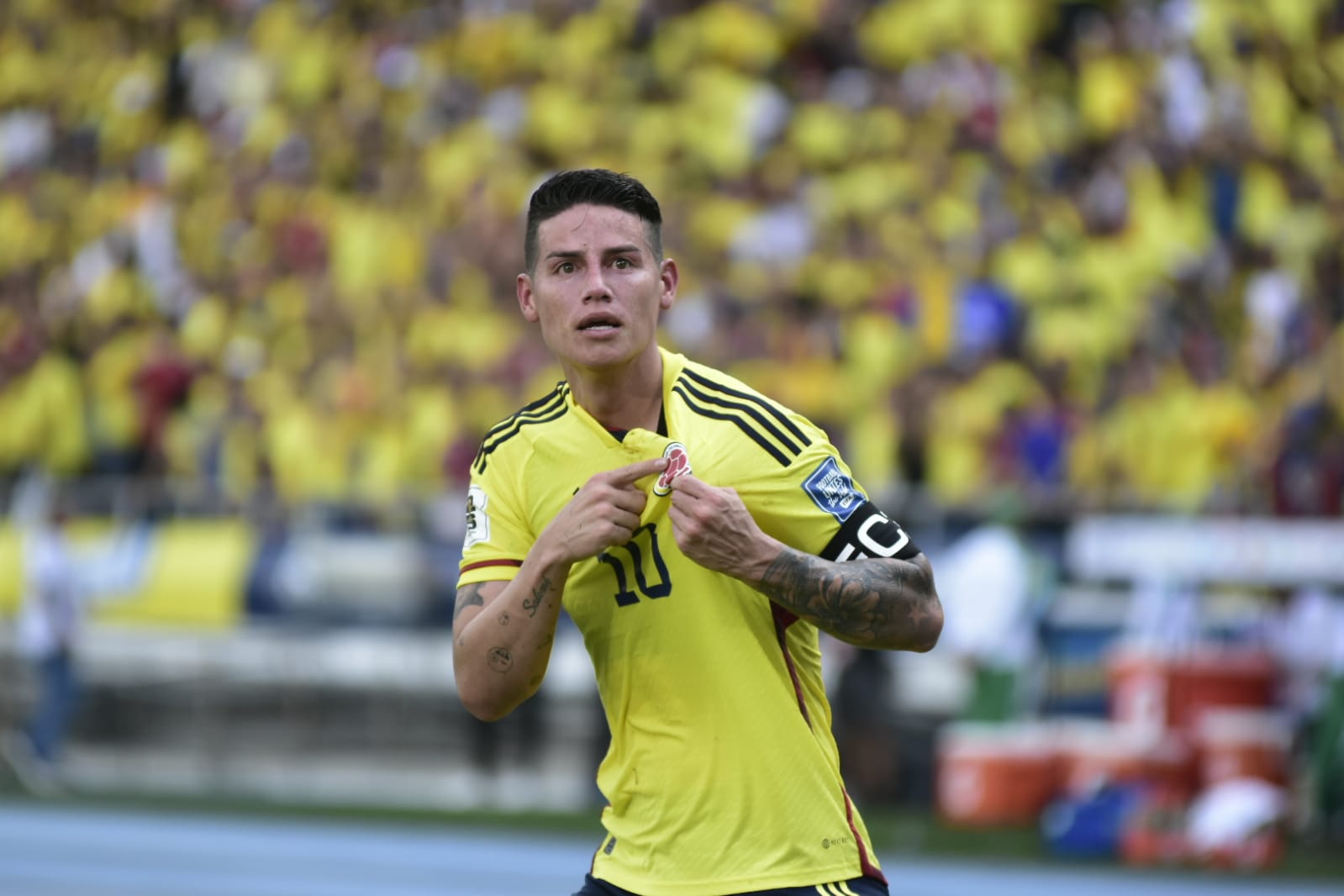 James Rodríguez mostrando el escudo de la selección Colombia.