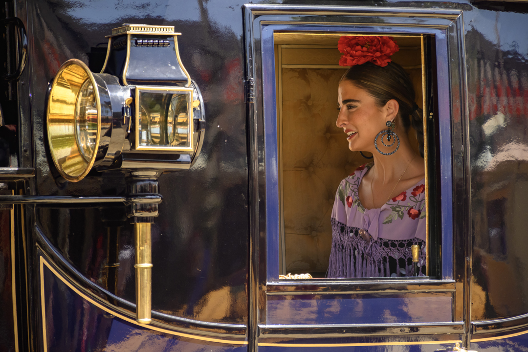 Una mujer vestida de flamenca en un carruaje.