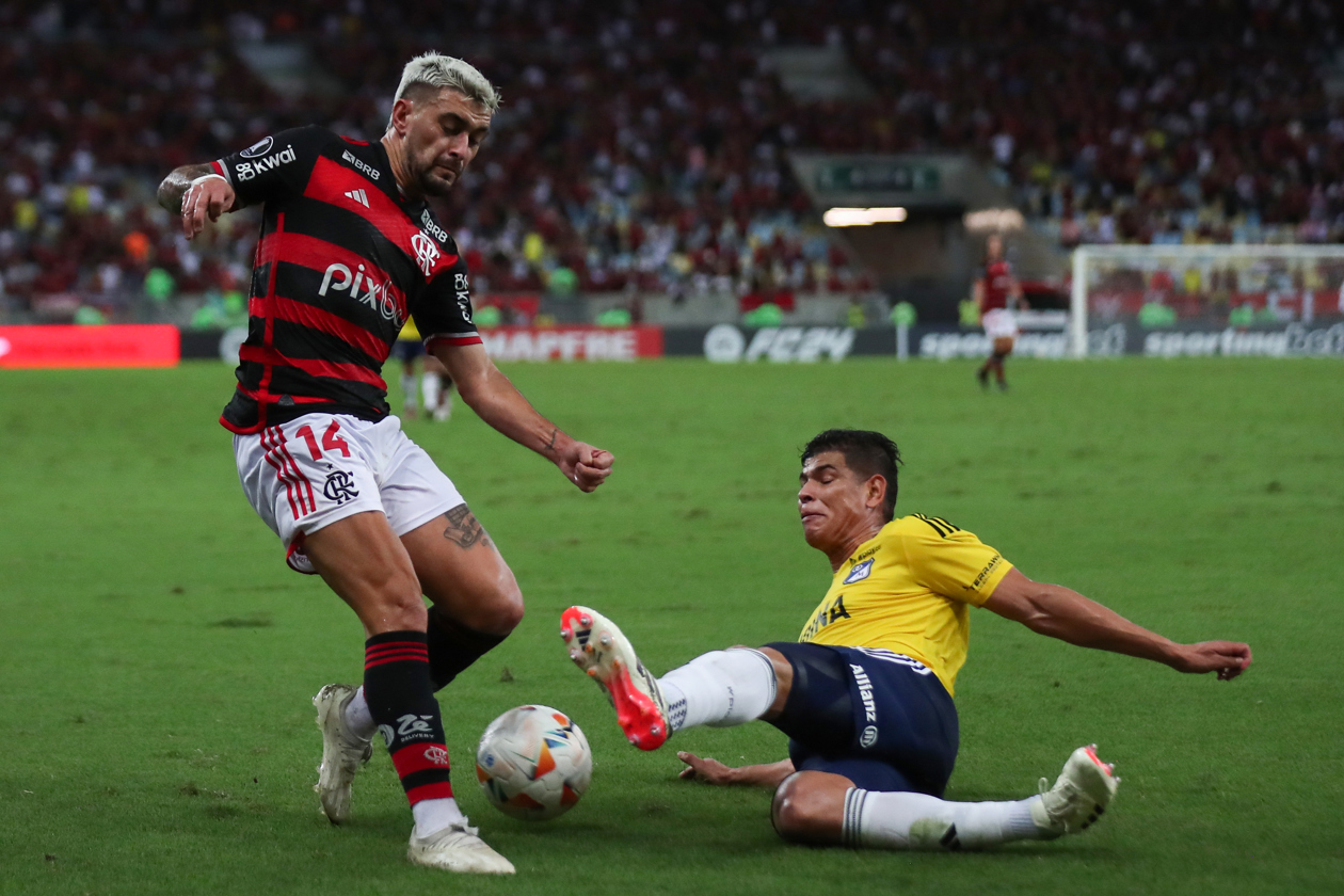 Giorgian De Arrascaeta (i) de Flamengo disputa el balón con Jorge Enrique Arias de Millonarios.