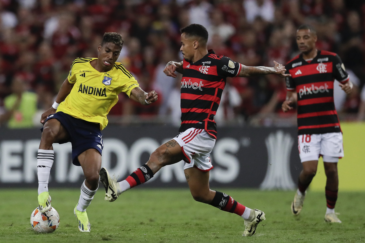 Nicolás de la Cruz (d) de Flamengo disputa el balón con Emerson Rivaldo Rodríguez de Millonarios