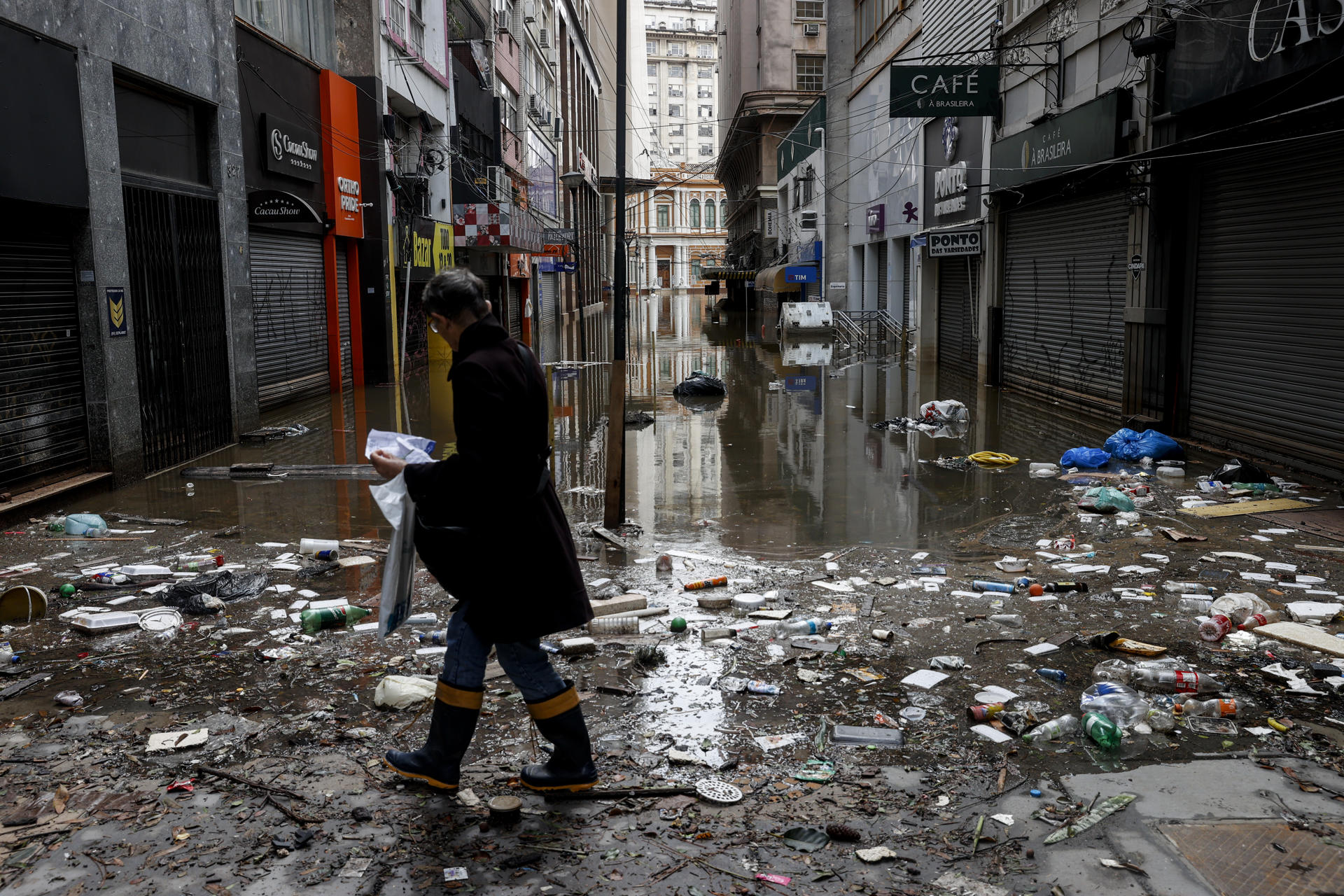 Una mujer camina por una calle inundada de agua y basura este lunes, en el centro de Porto Alegre