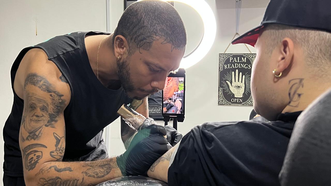 Juan Manuel Charris realizando un tatuaje.