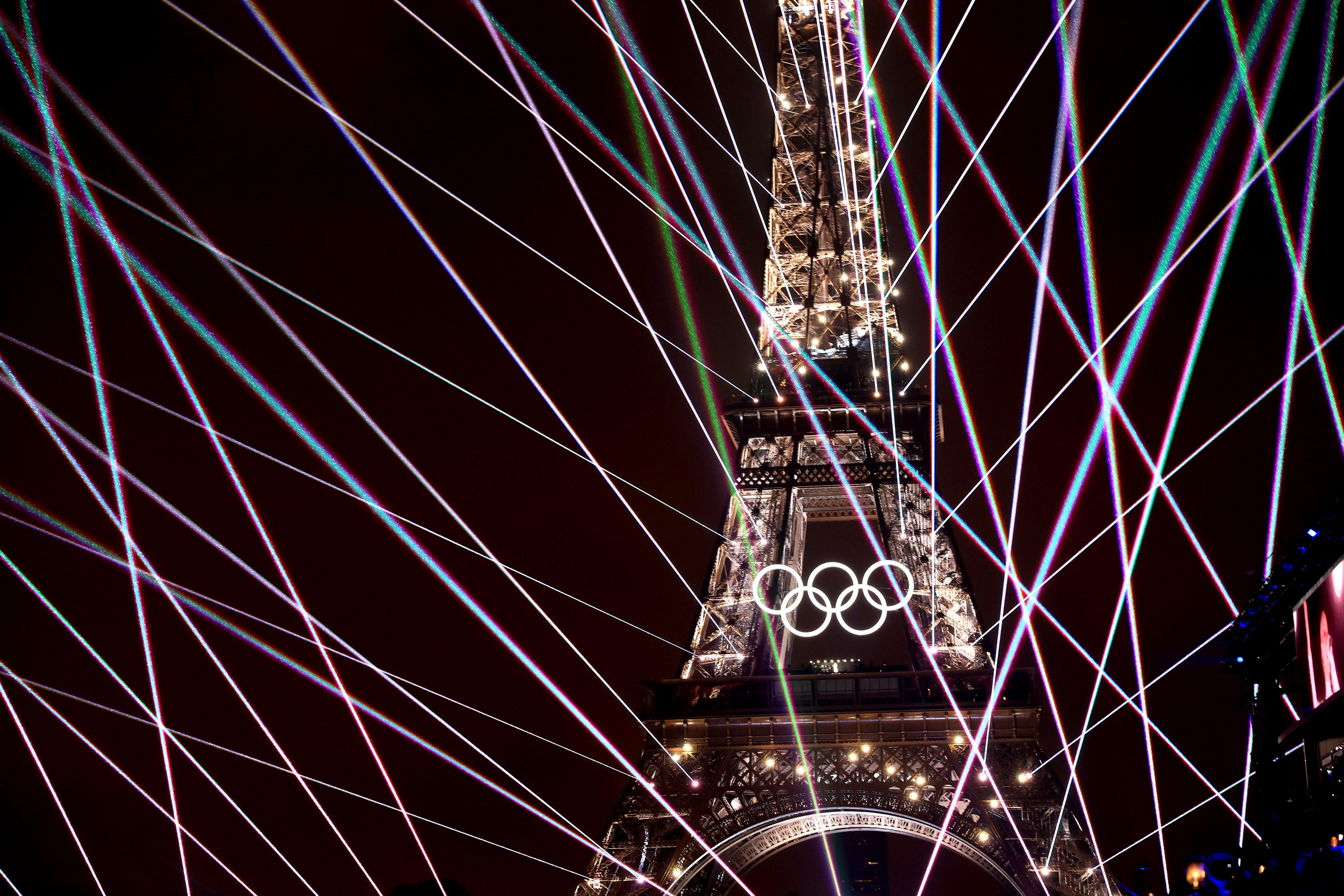 La torre Eiffel iluminada y exhibiendo los aros olímpicos.