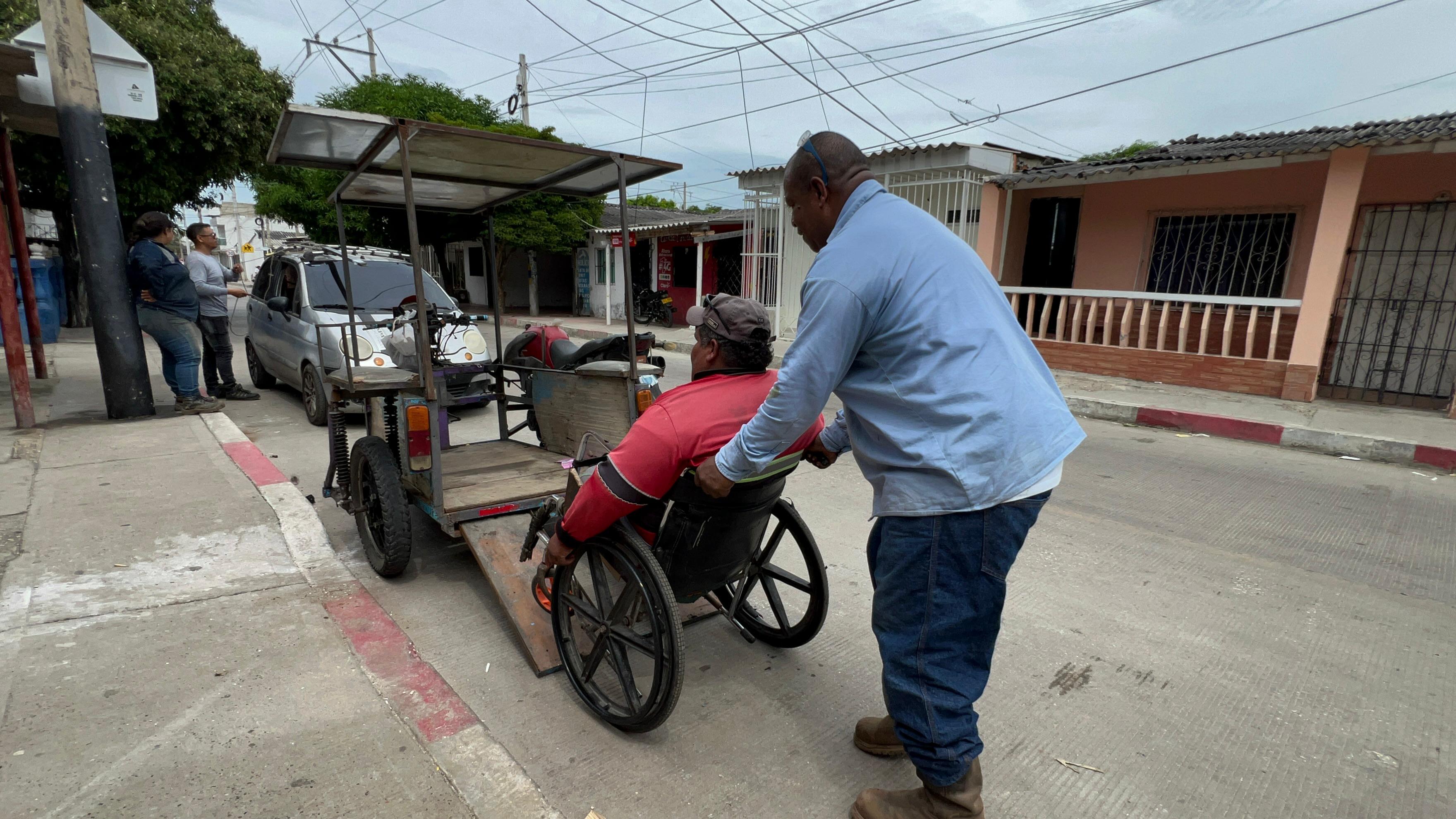 Felipe Orozco subiendo a Wilmer Fandiño a su motocicleta.