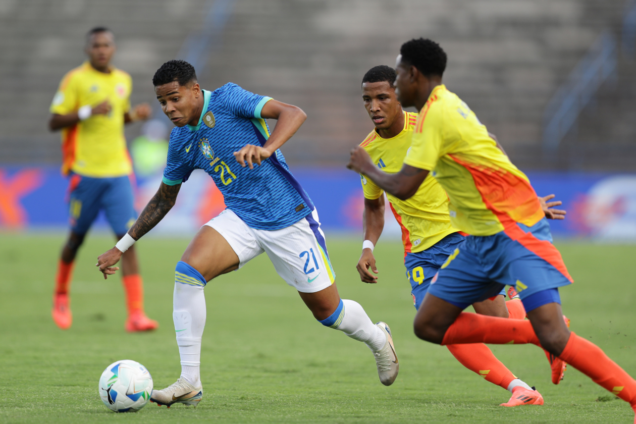 El brasileño Wesley intenta escapar de la marca de dos jugadores colombianos.