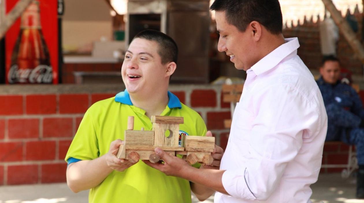 Alegría de un joven con discapacidad al recibir su trencito de madera.