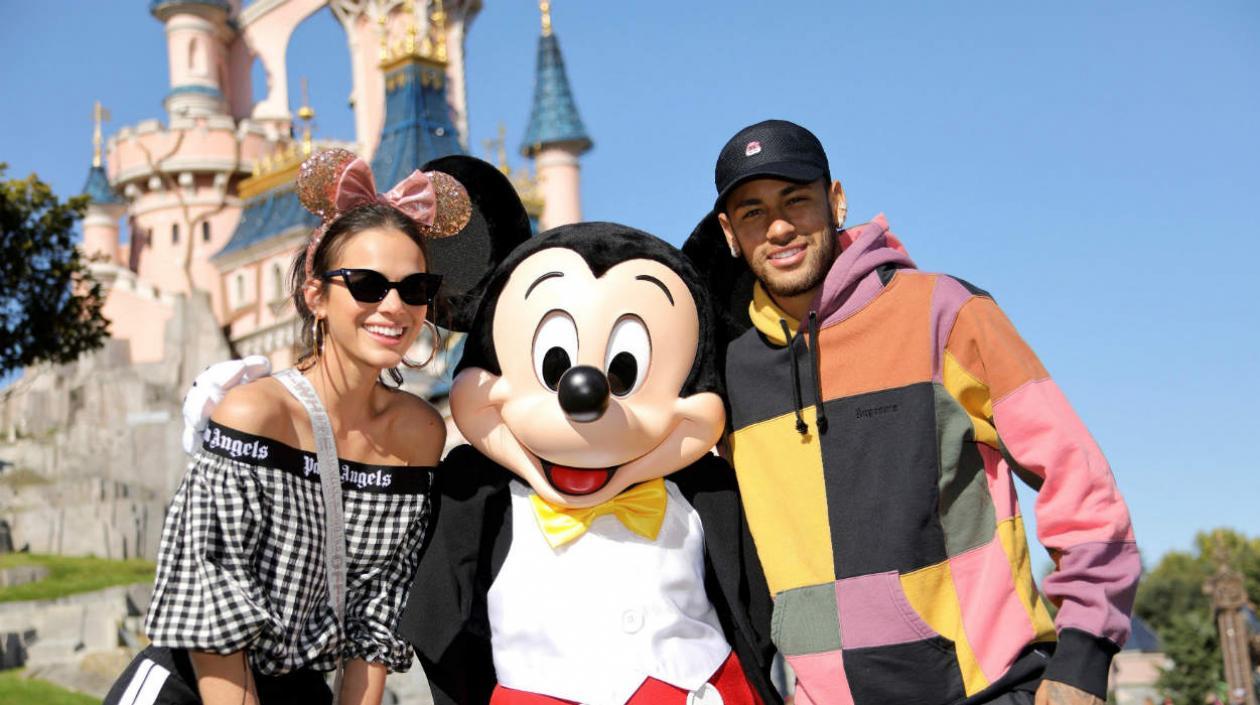 Bruna y Neymar al lado del ratón Mickey. 