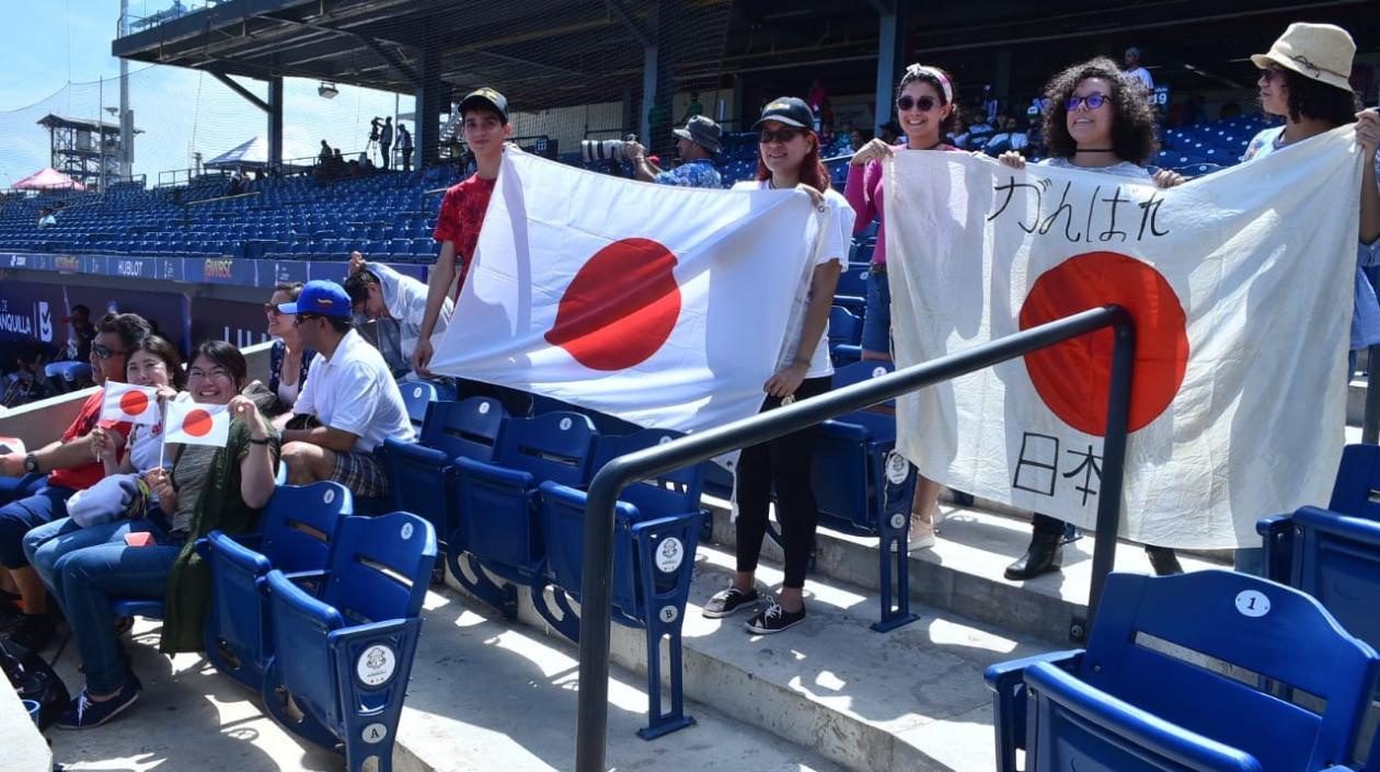 El grupo de japoneses y los barranquilleros con las banderas grandes. 