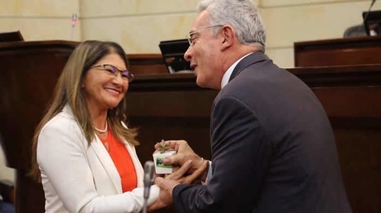 Sandra Ramírez entregó una planta a Álvaro Uribe, en el Congreso.