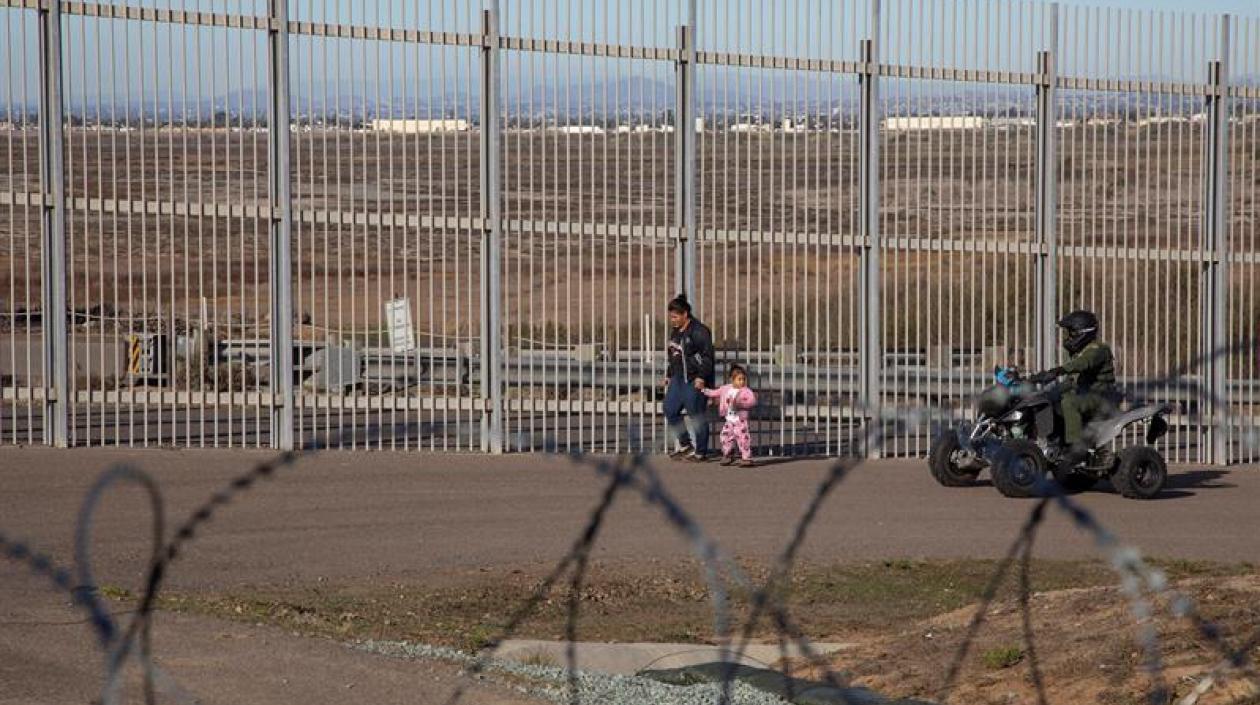 Imagen para ilustrar la nota. Una mujer migrante es detenida por la policía estadounidense hoy, en el muro fronterizo de la ciudad de Tijuana, en Baja California (México). 