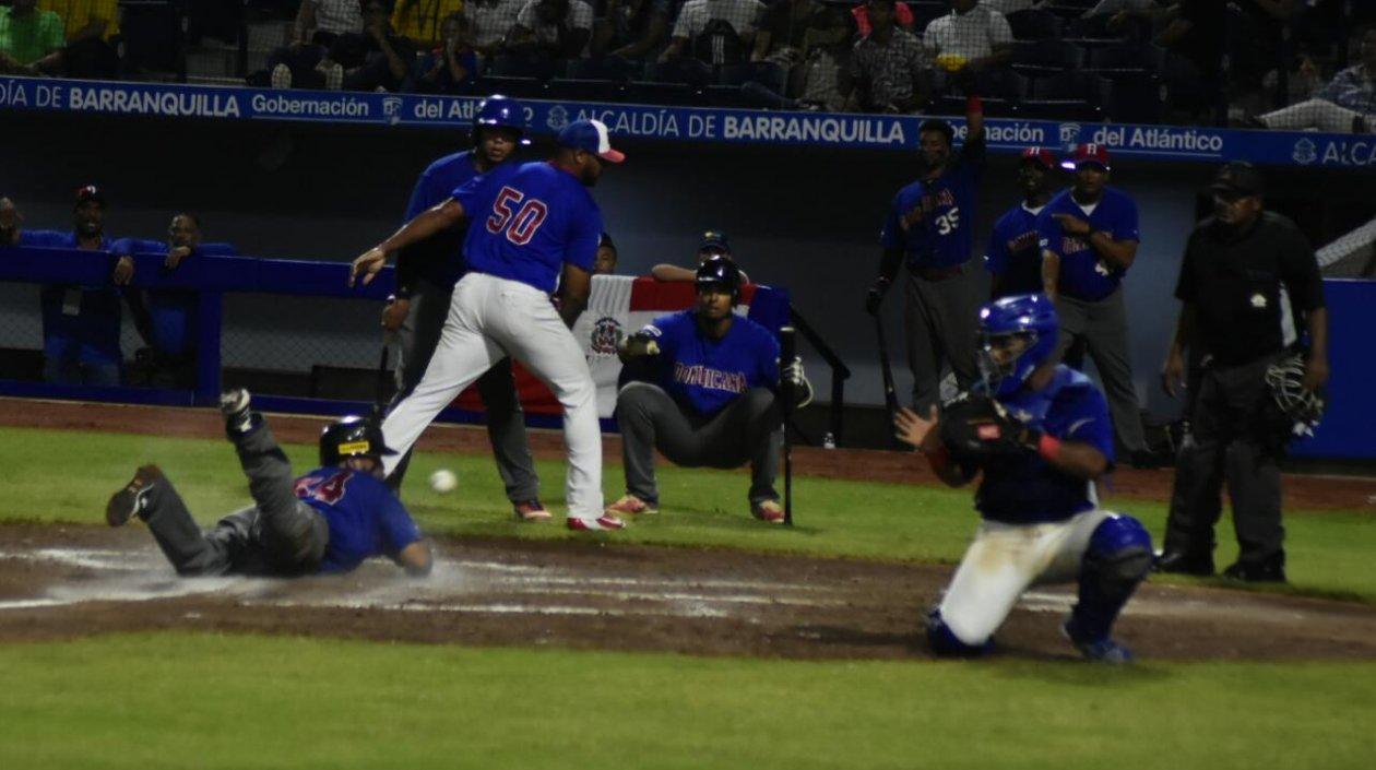 Un dominicano se desliza y toca el plato en el partido ante Puerto Rico, que ganaron 7-2.
