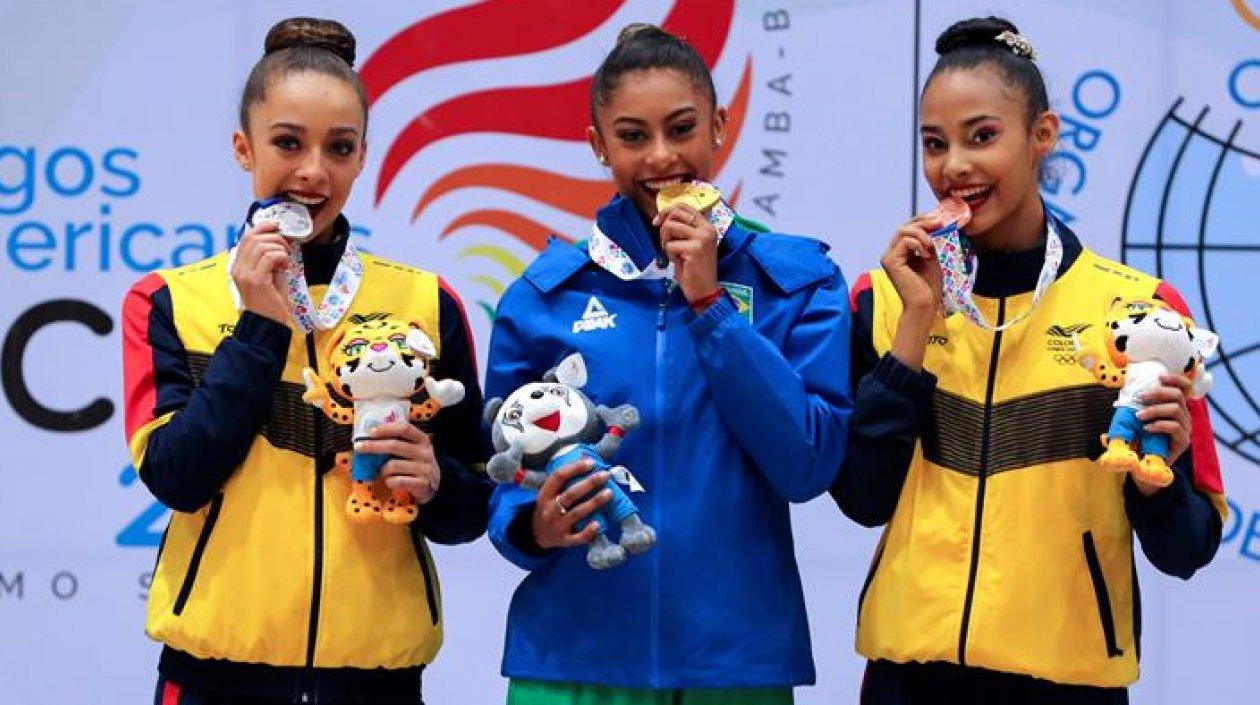 La gimnasta brasileña Bárbara Godoy Domingos (c), y las colombianas Lina Dussan (i) y Oriana Viñas (d) posan durante la ceremonia de premiación de las competencias de gimnasia rítmica.