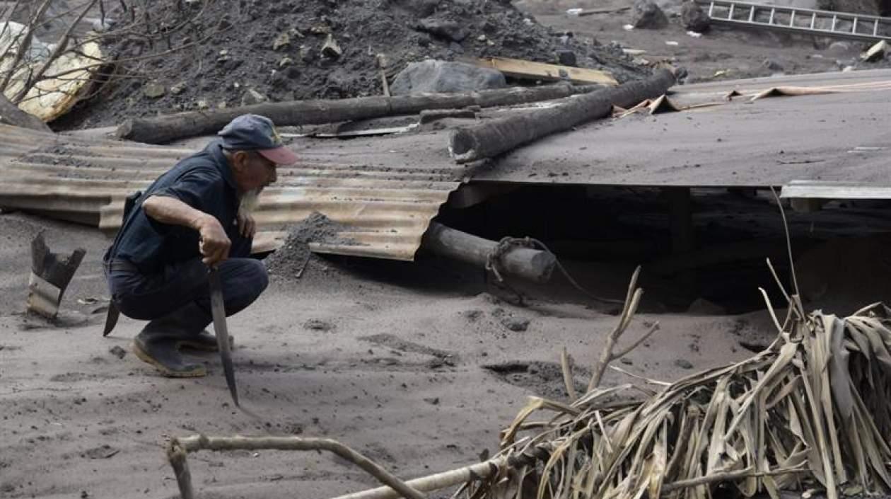 Un hombre observa los daños a una vivienda afectada por el volcán de Fuego.