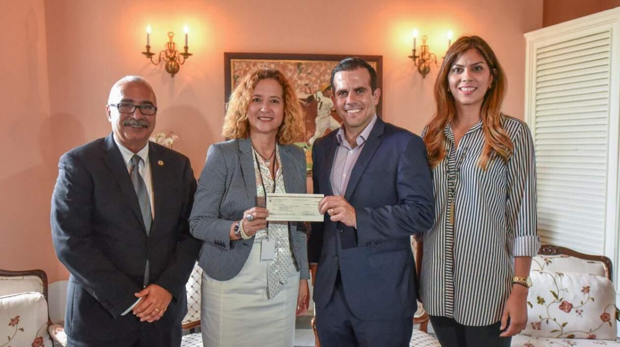 El Gobernador de Puerto Rico, Ricardo Rossello, entrega el dinero para el evento. 
