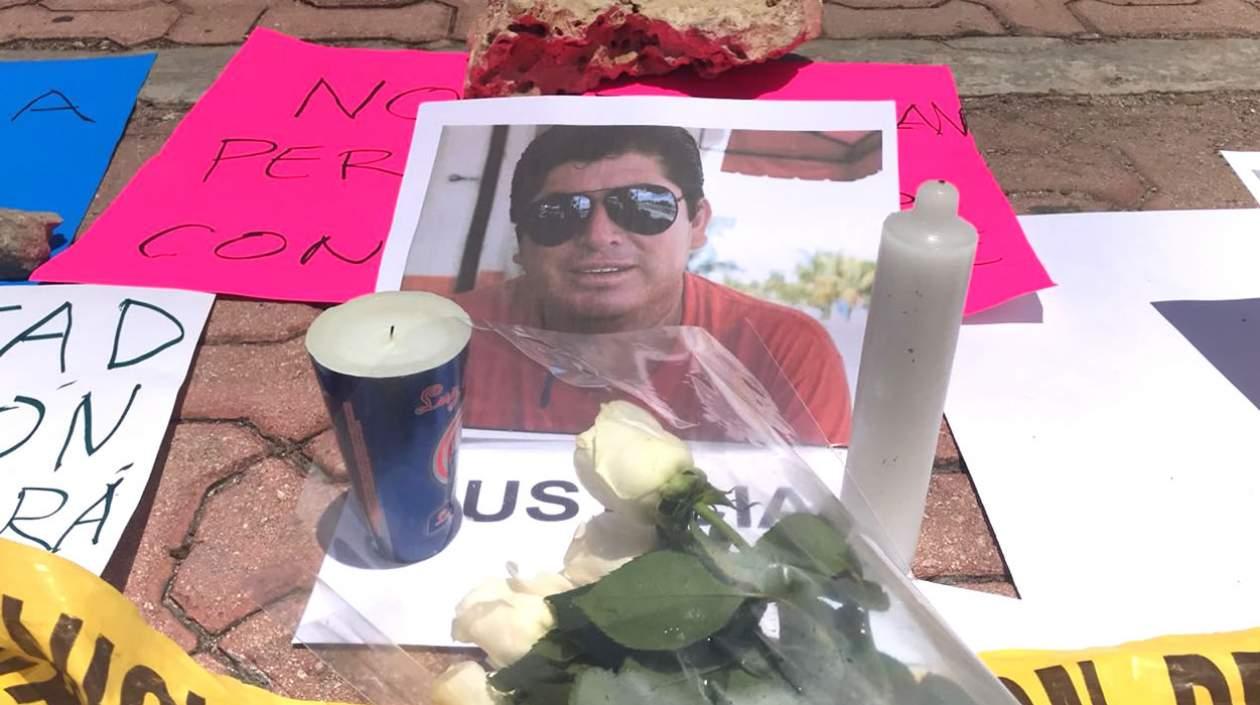  Detalle de una ofrenda de flores y velas junto a una retrato del periodista mexicano José Guadalupe Chan Dzib