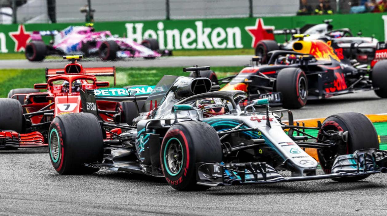 Lewis Hamilton pasa por delante de un monoplaza del Ferrari. 