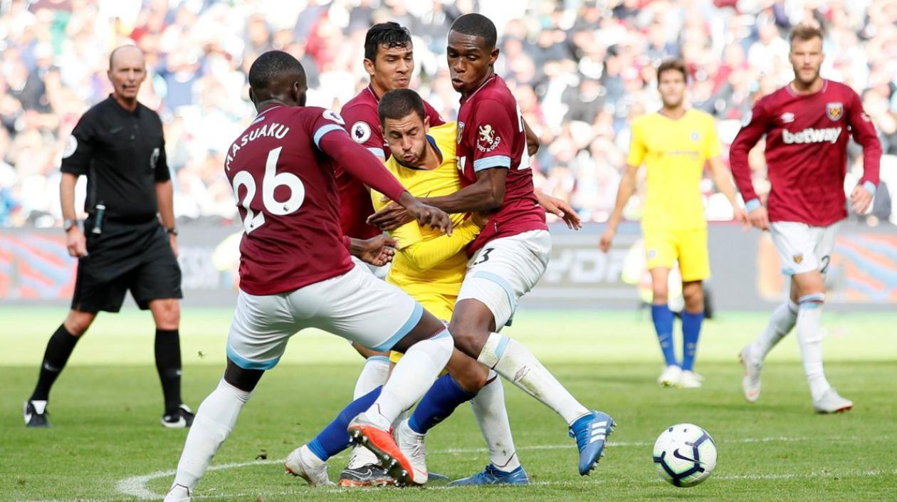 El volante del Chelsea, Eden Hazard, frenado por defensores del West Ham. 