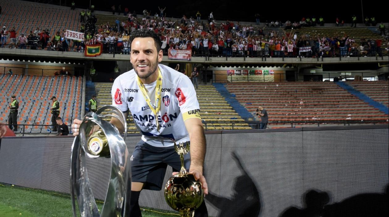 Sebastián Viera celebra con los trofeos de ganador de la Liga Águila. 