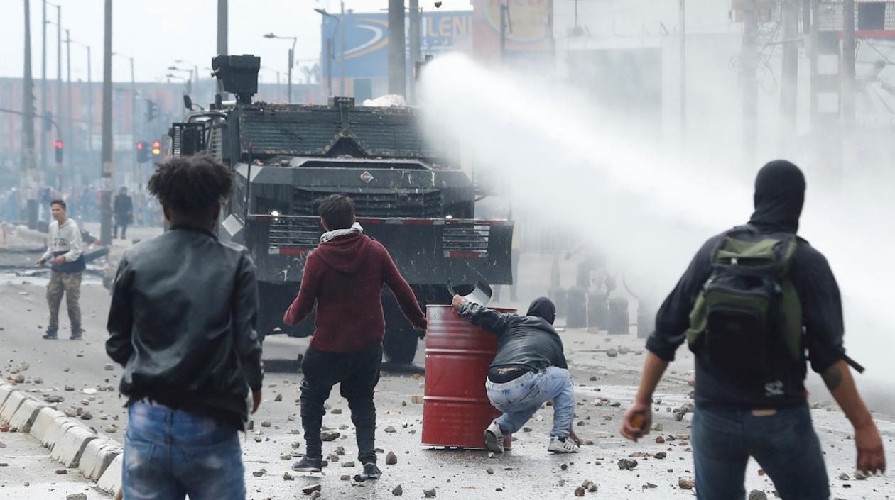 Una tanqueta de la policía antidisturbios enfrenta a un grupo de manifestantes este viernes, en un sector de Patio Bonito, sur de Bogotá (Colombia).