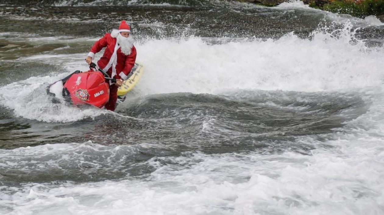 Momento en que el hombre disfrazado de Papá Noel aparece en una moto acuática.